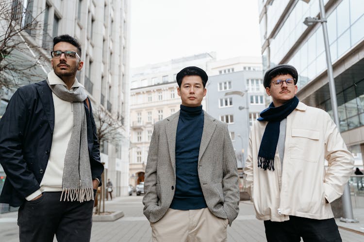 A Group Of Men Standing On The Street While Looking With A Serious Face