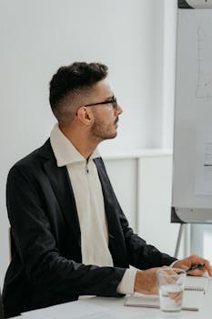 Young businessman reviewing charts during a modern office meeting for strategic planning.