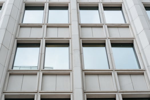 Image of a modern building facade with glass windows, showcasing contemporary architecture.