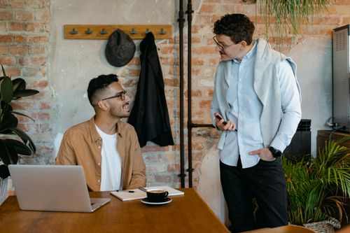 Free Two men discussing ideas in a stylish office with exposed brick walls. Stock Photo