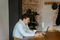 Man in Gray Sweater Using Laptop Computer