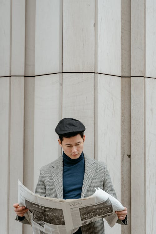 Free Man in Gray Coat Reading a Newspaper  Stock Photo