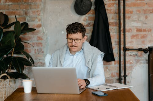 Free Man in Light Blue Long Sleeve Shirt Using Silver Laptop Stock Photo