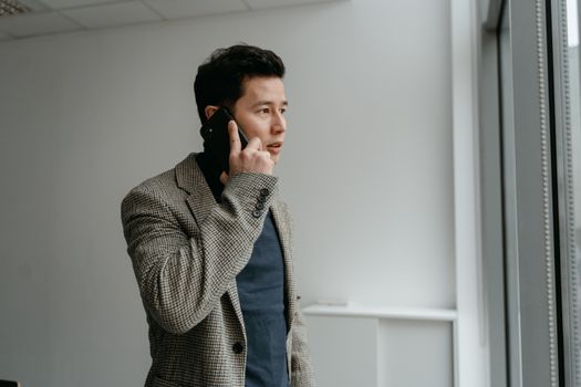 Man in Gray Coat Holding Black Smartphone