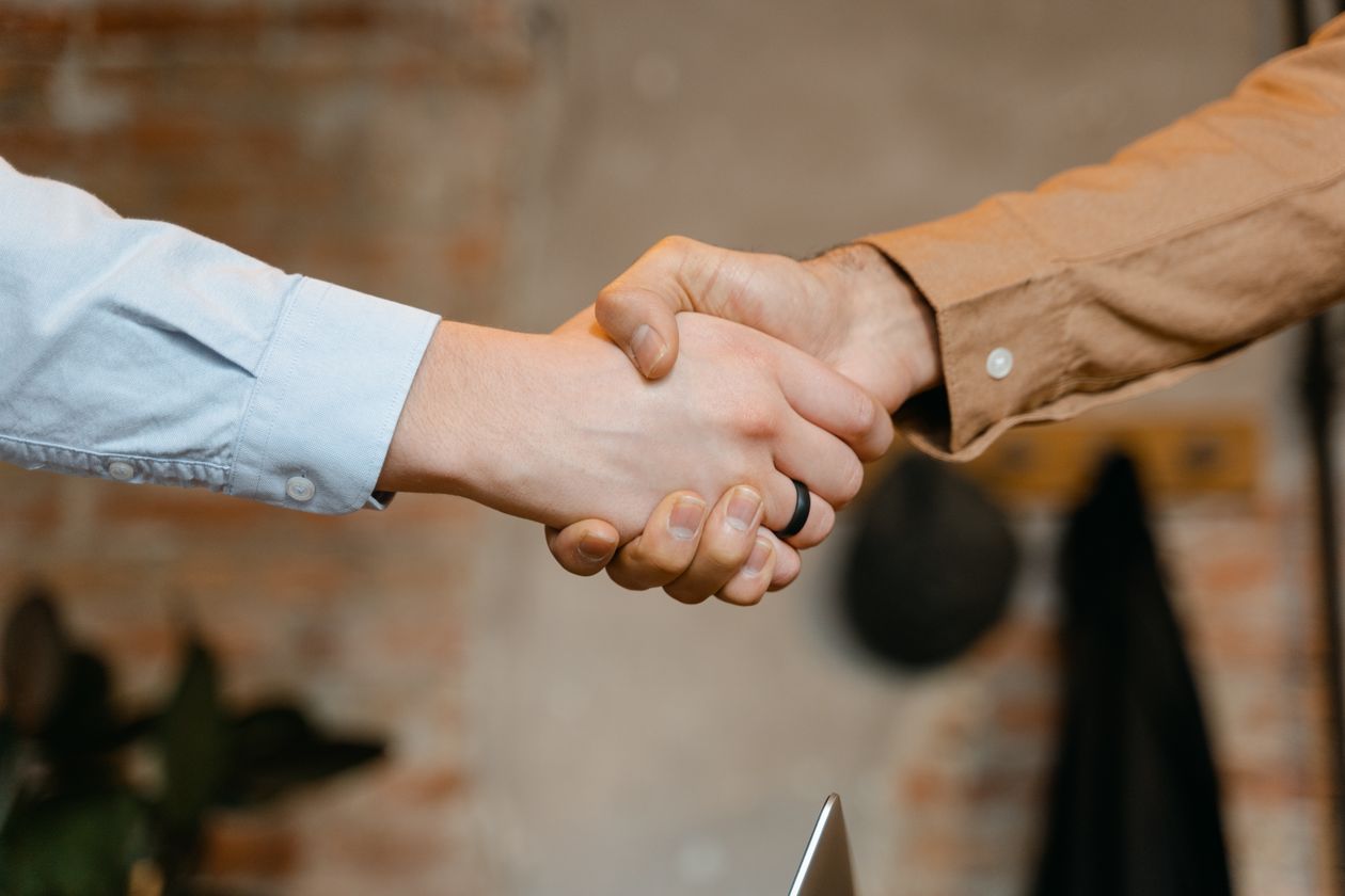 Close-up of a firm handshake symbolizing a closed sale, representing Myron Golden's approach to sales