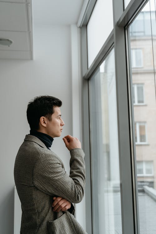 Side View of Man in Coat Looking Outside 
