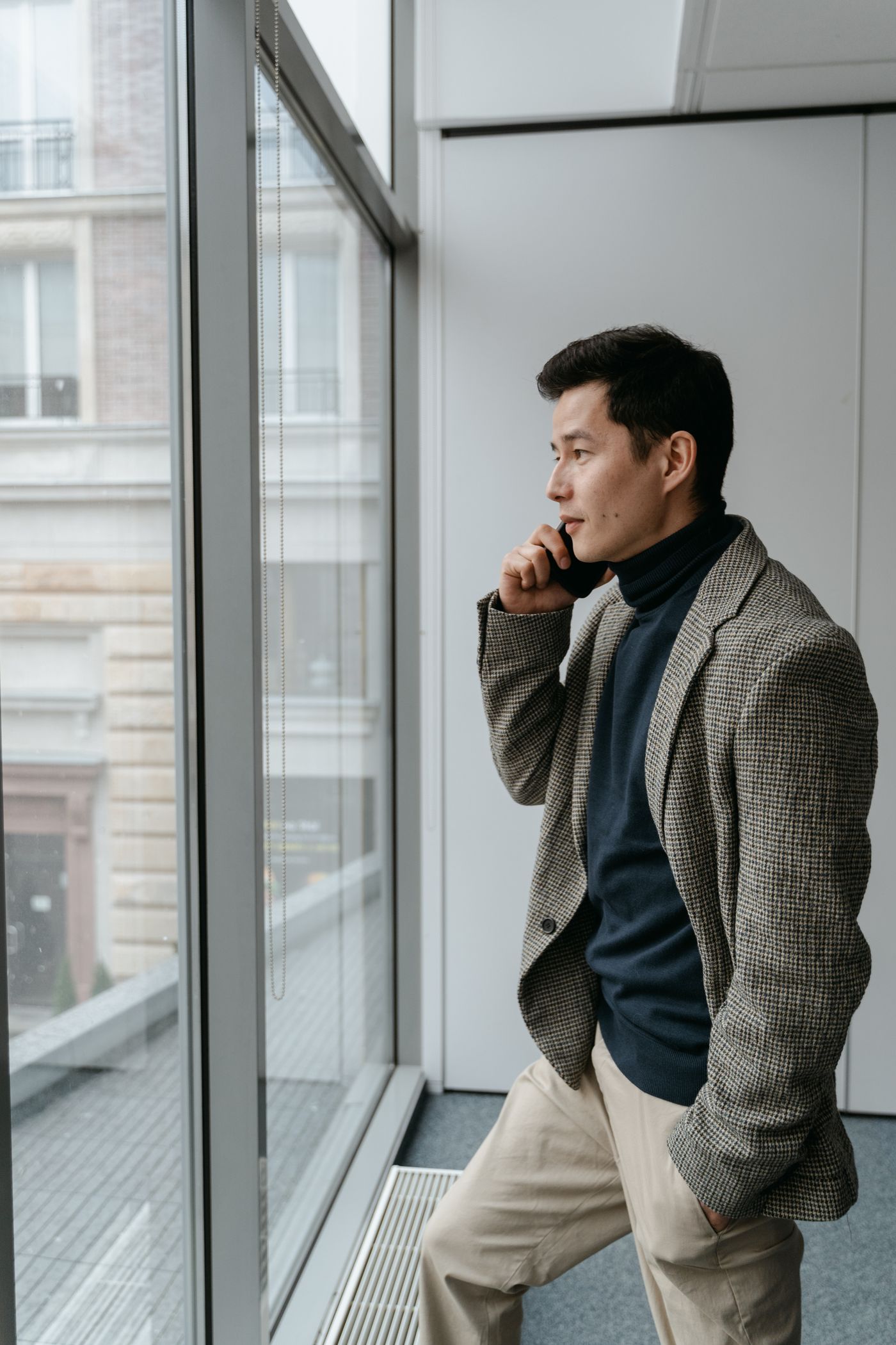 Finance professional standing by a window in an office