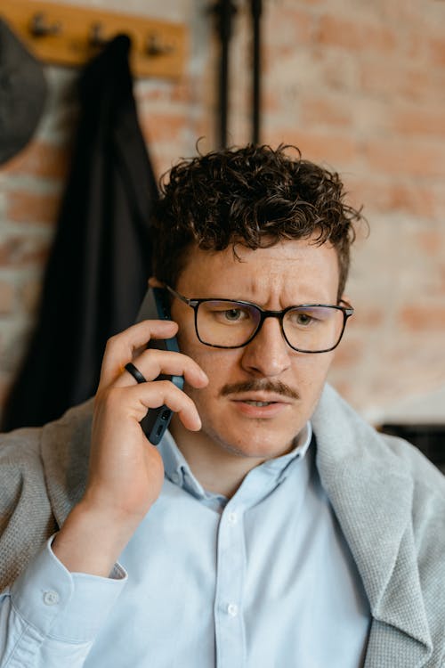 Man Wearing Eyeglasses on a Phone Call