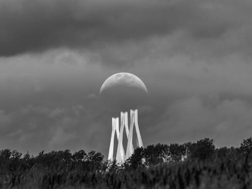 Grayscale Photo of Moon on Cloudy Sky