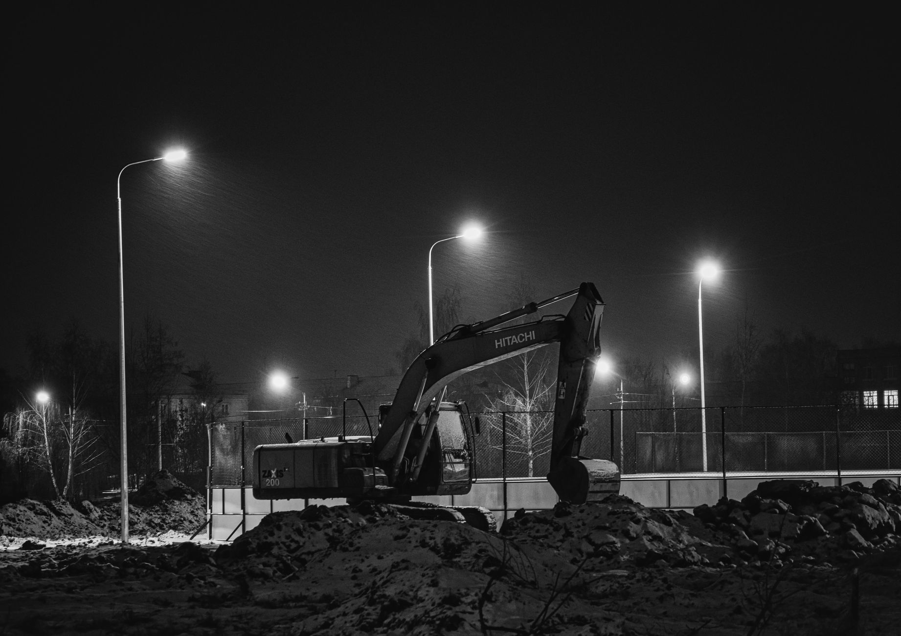 Excavator working under site lighting