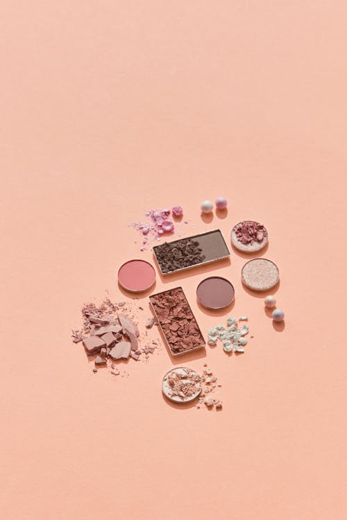 Whole and Crushed Eyeshadows and Powders on Pink Background