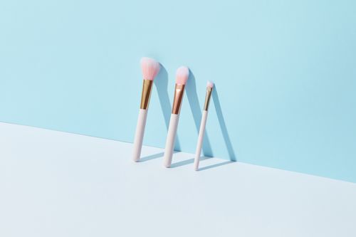 Free A minimalist setup of makeup brushes on a light blue background, highlighting beauty essentials. Stock Photo