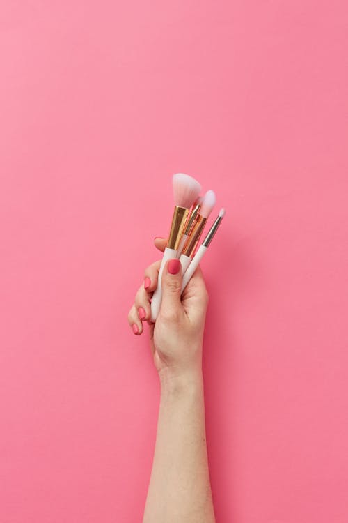 A Person Holding Makeup Brushes