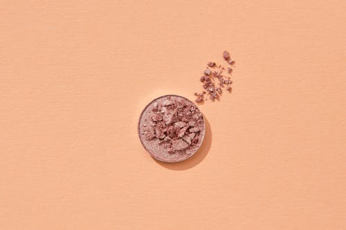 Broken Cosmetic Powder on Orange Surface