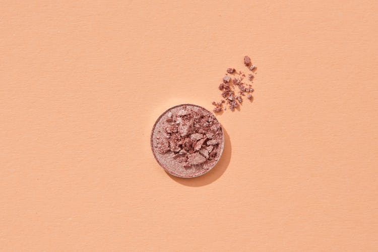 Broken Cosmetic Powder On Orange Surface