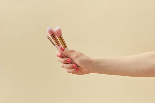 A Person Holding Makeup Brushes