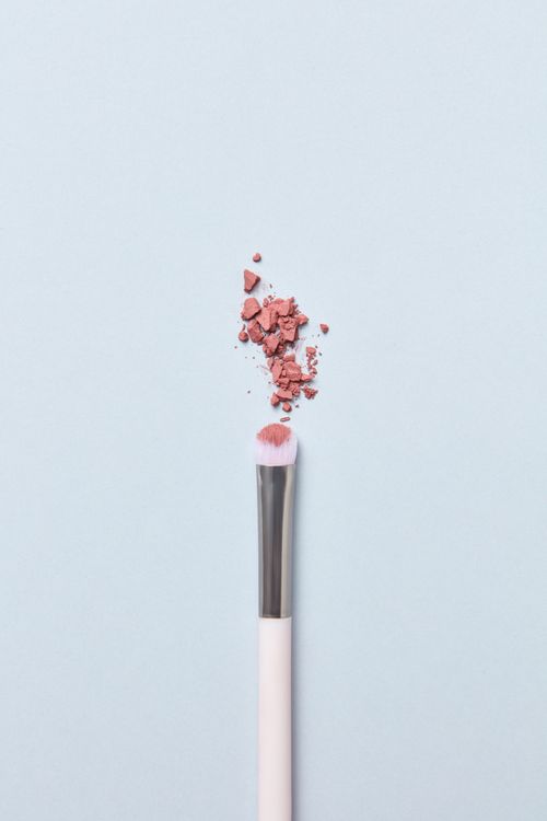 Free Flat lay image of a makeup brush with crushed blush on a minimalist light background. Stock Photo