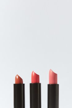 Three lipsticks in different shades arranged against a plain white background.
