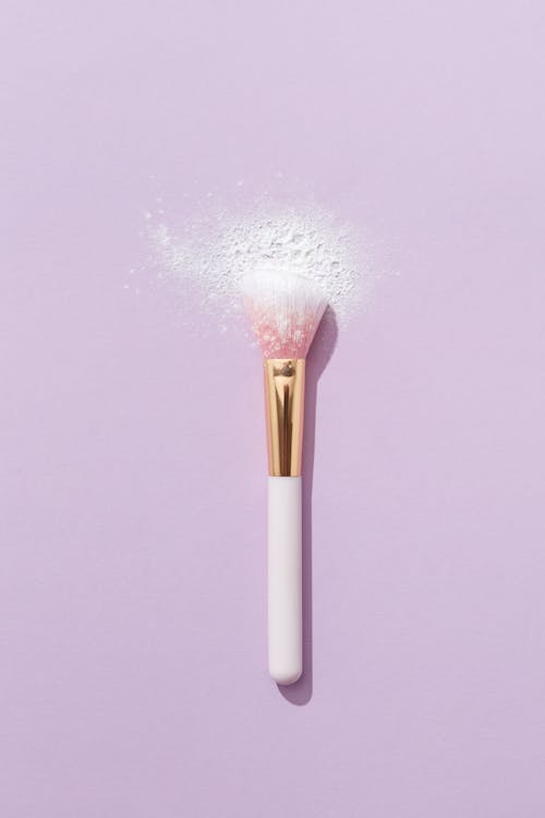 Close-Up Shot of a Makeup Brush on a Purple Surface