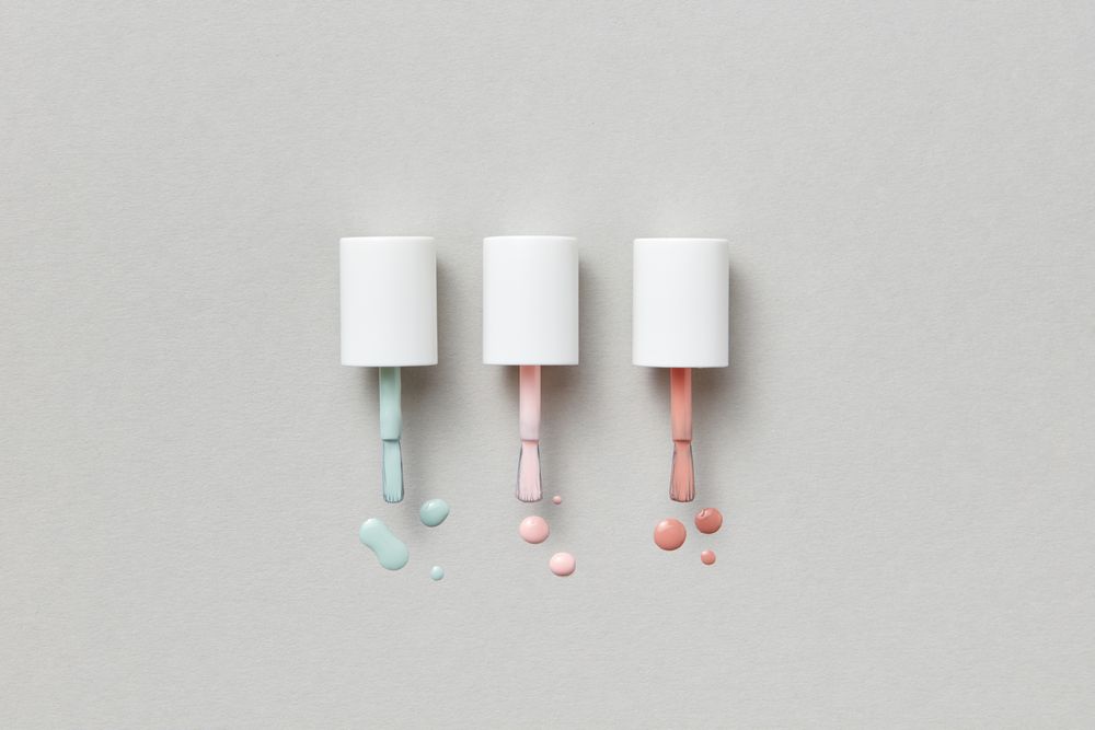 Three lacquer brushes leaving colour on a grey surface