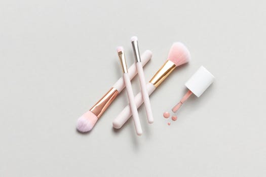 A flat lay of makeup brushes and spilled nail polish on a light surface for beauty concepts.