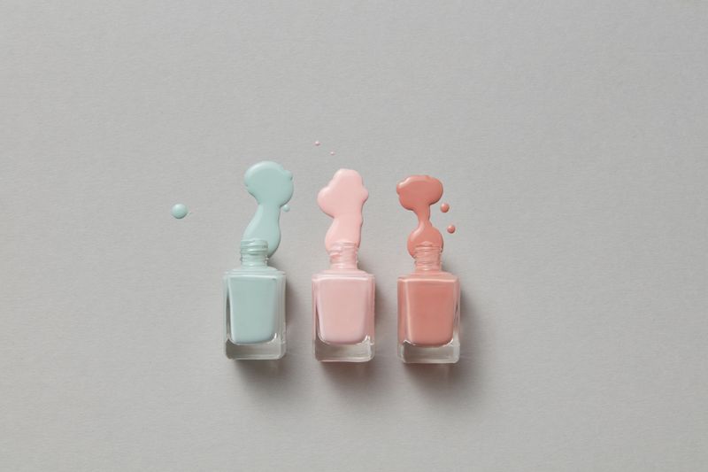 Lacquer poured beside three open bottles