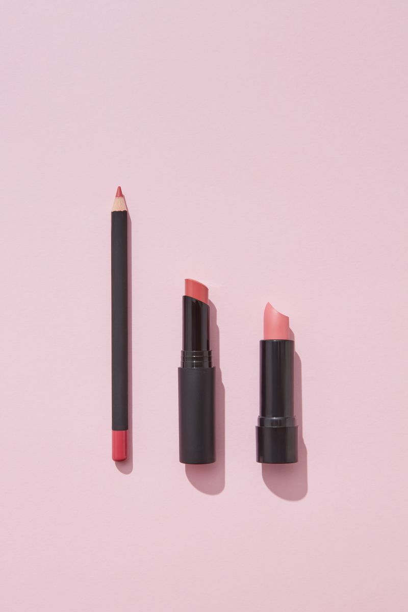 Lipsticks arranged against a pink background