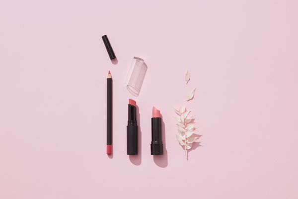 Lipsticks and a liner arranged on a pink surface, photo by DS stories on Pexels