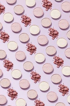 Aesthetic flat lay of pink and white makeup powders on a lavender surface, creating a chic pattern.