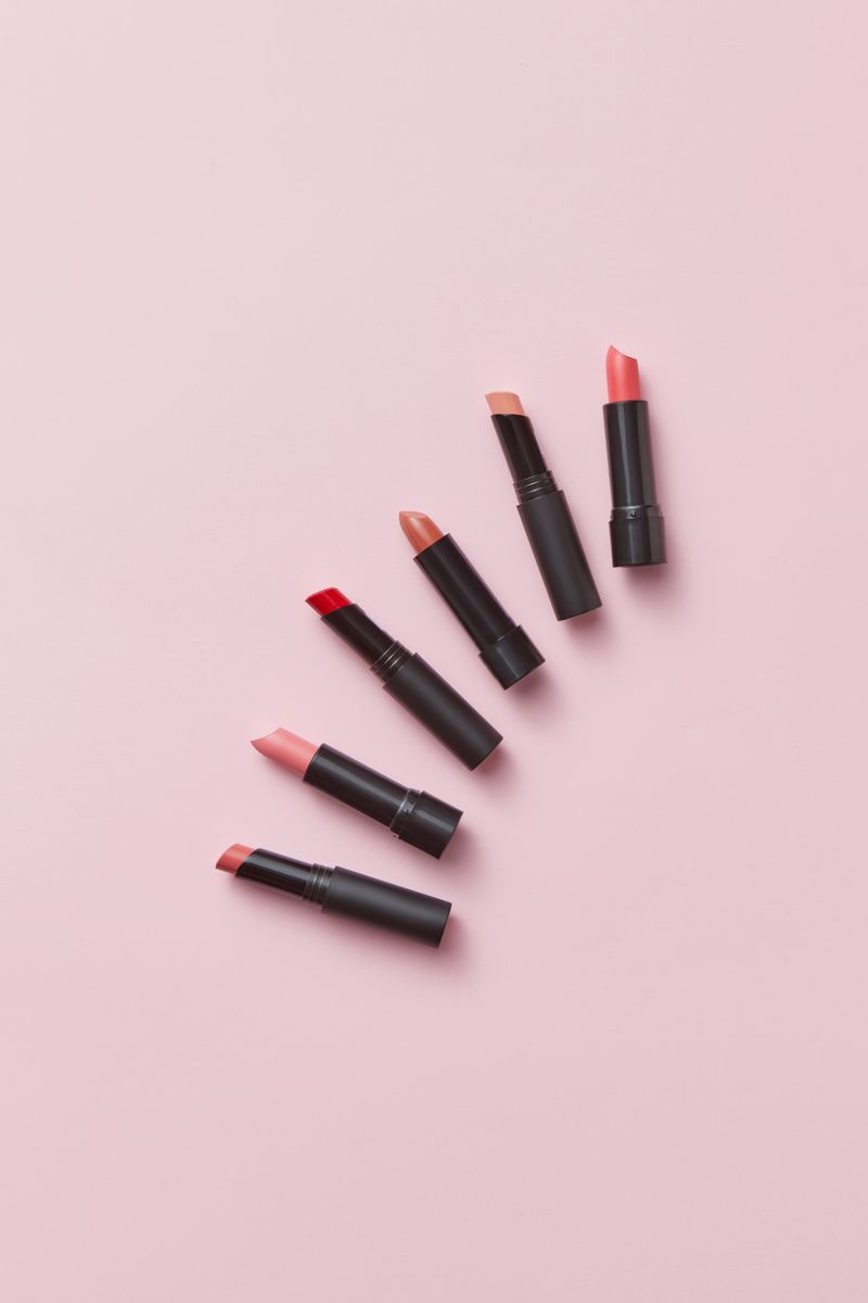 Pink lipsticks arranged on a soft pink background