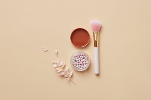 Free Cosmetic Product on Round Container and a Makeup Brush Stock Photo