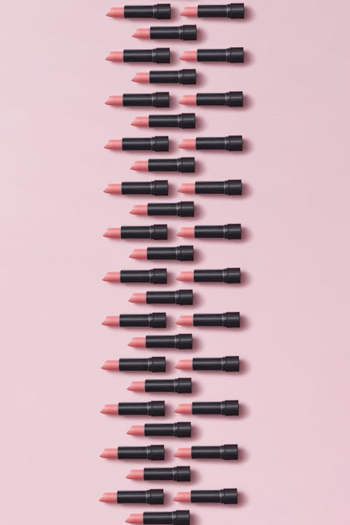 Lipsticks Arranged on Pink Surface