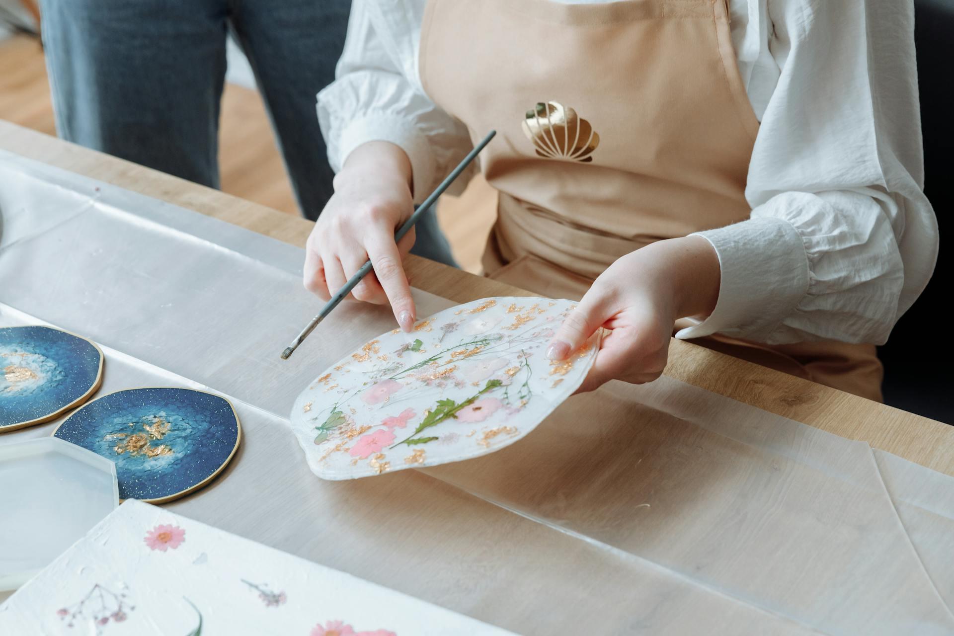 Close-up view of a person painting art pieces in a studio with a focus on creativity and detail.