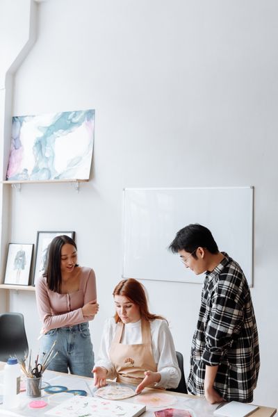 Three collaborators reviewing work together in a bright studio — photo by Thirdman on Pexels