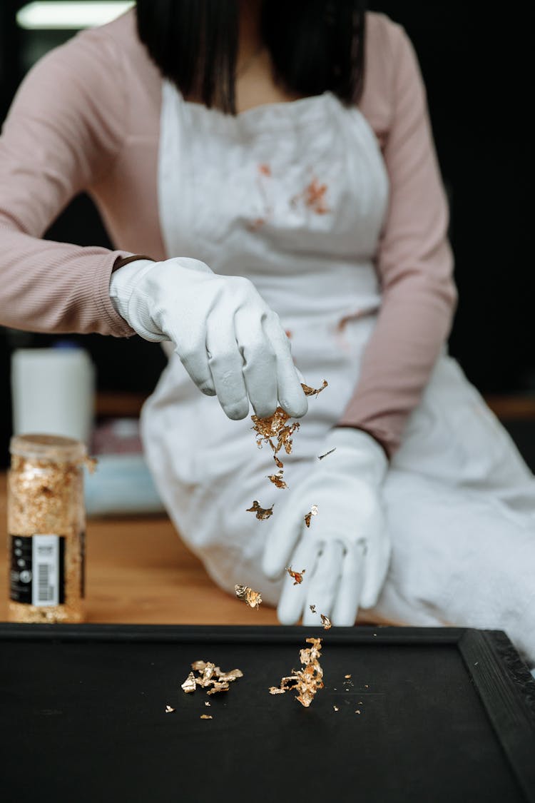 A Close-Up Shot Of A Woman Sprinkling Gold Flakes
