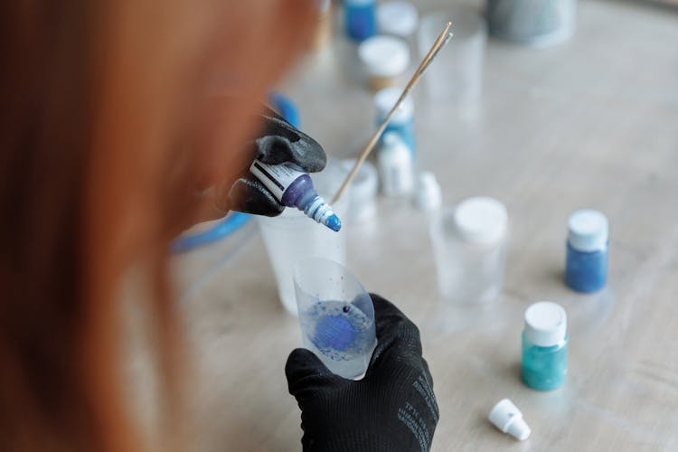 Hands In Gloves Pouring Liquid From Vial