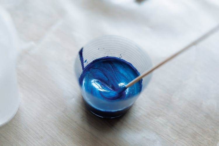 Close-Up Shot Of A Person Mixing A Blue Paint