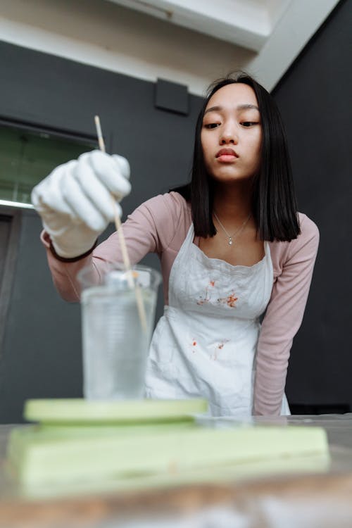 Woman Mixing Resin with Skewer 