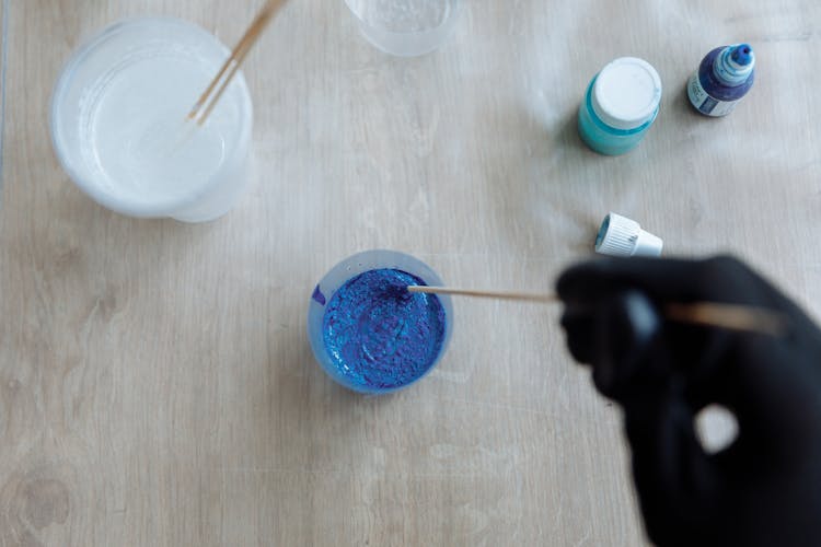 Close-Up Shot Of A Person Mixing A Blue Paint