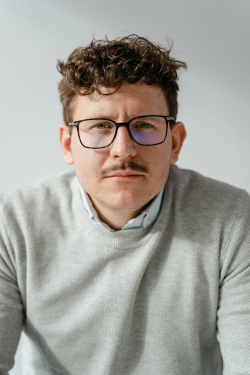 

A Portrait of a Man Wearing Eyeglasses and a Gray Sweater