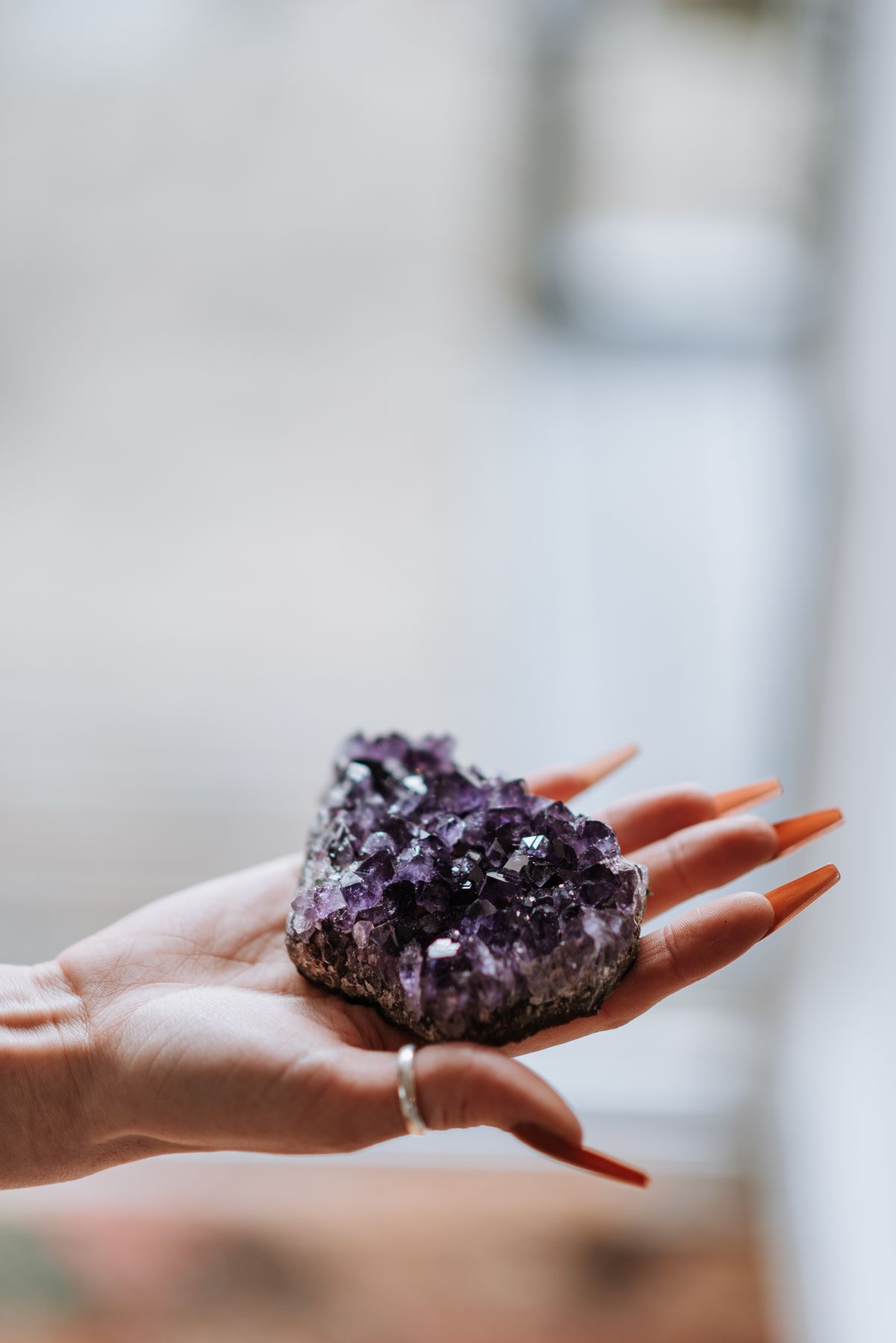 Hand holding a small amethyst cluster