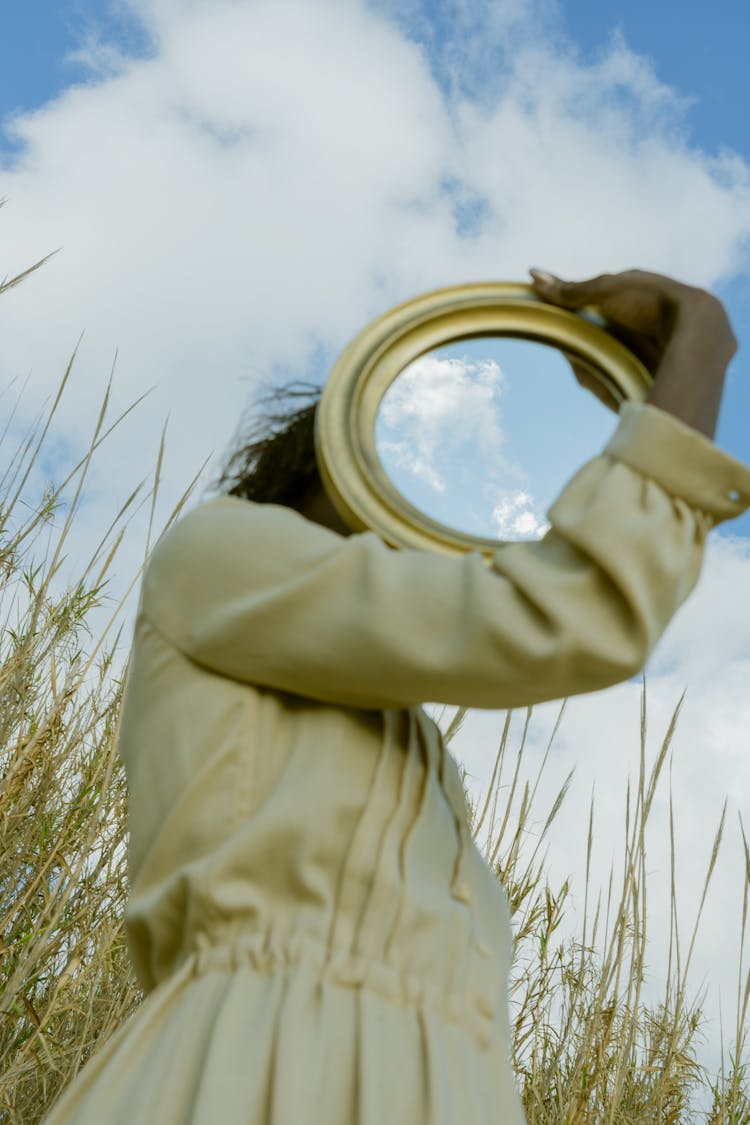 Woman Holding Circular Mirror In A Field 