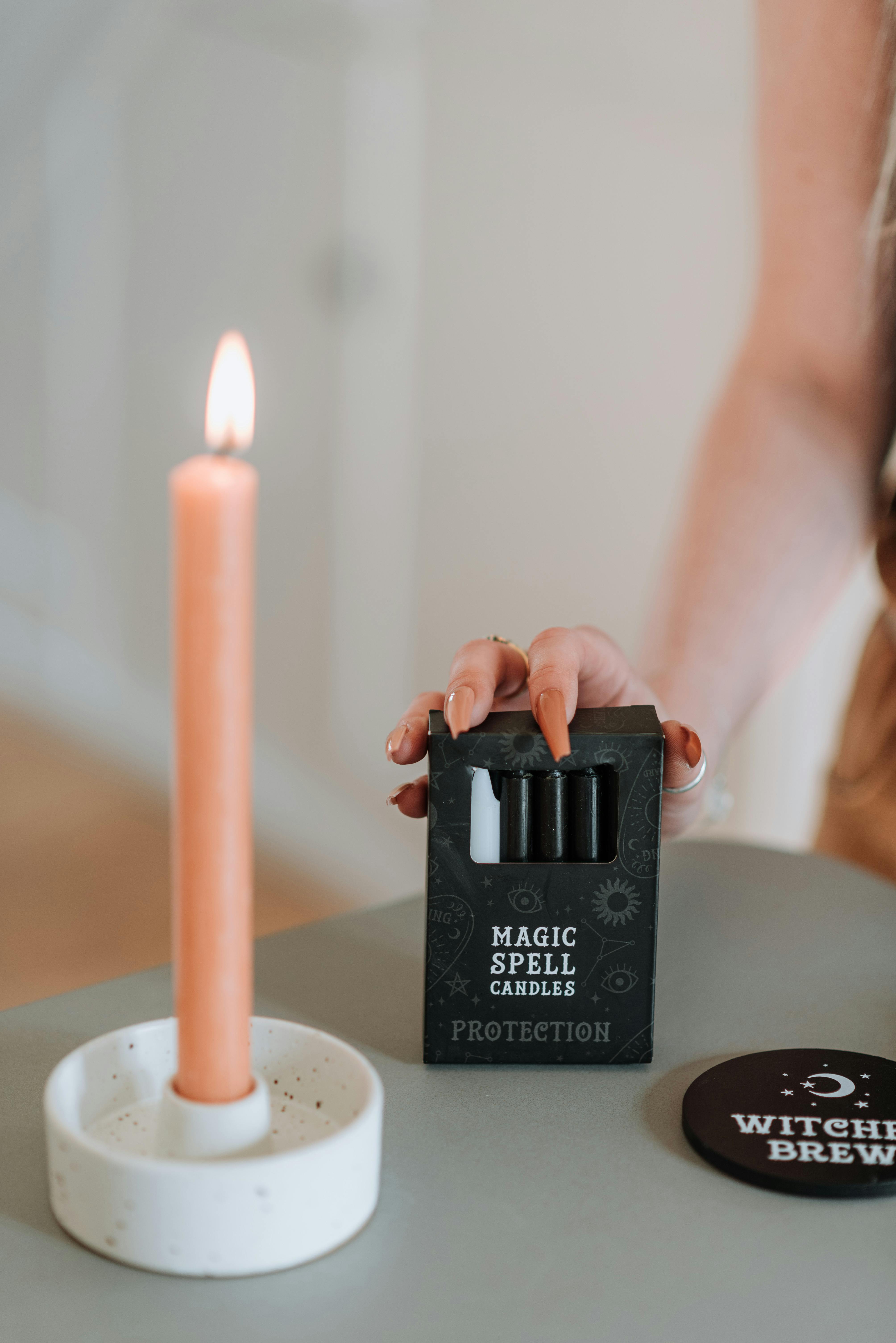 enchantress touching package with magic spell candles at table