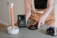 Enchantress with magic box and glowing candle during ritual