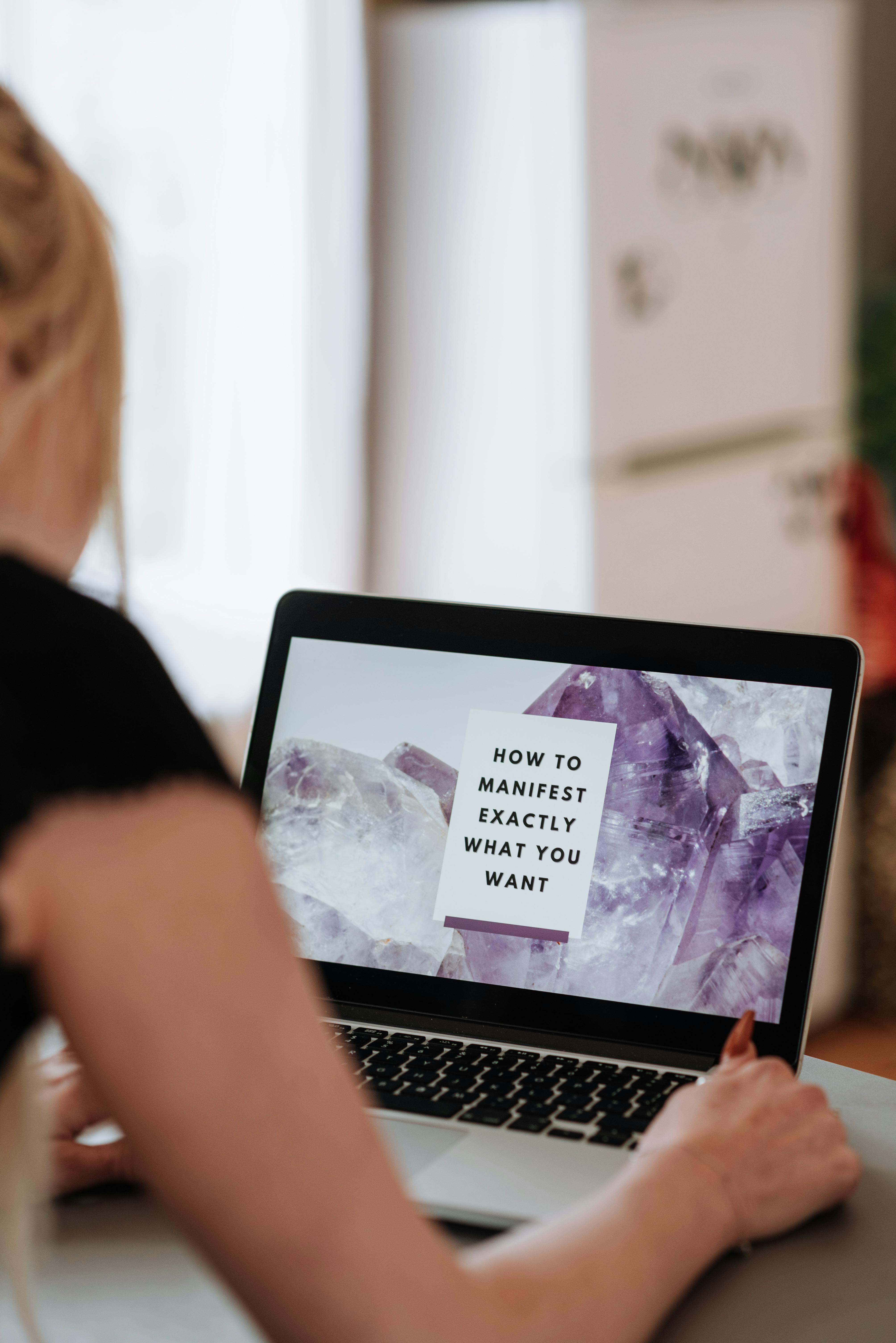 woman reading inspirational phrase on screen of laptop