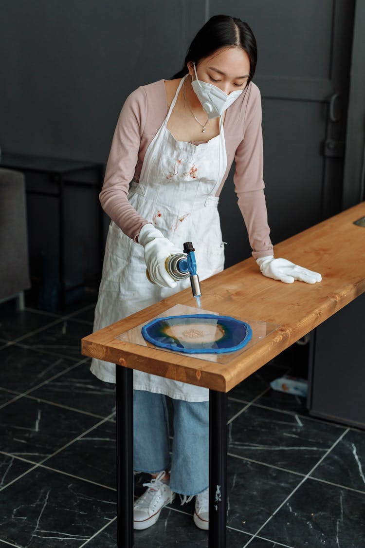 A Woman Torching Resin