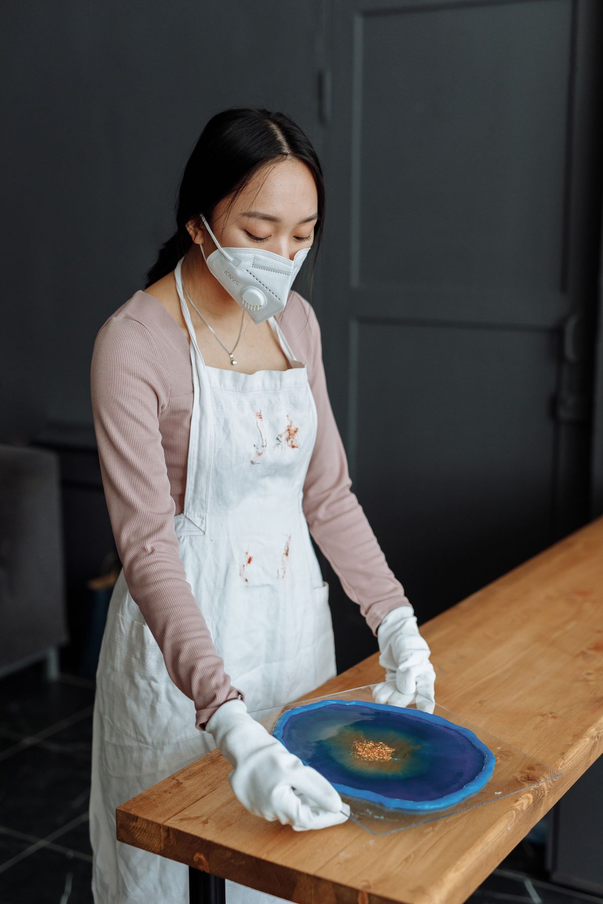 Masque, tablier et gants : la tenue de base pour travailler la résine.