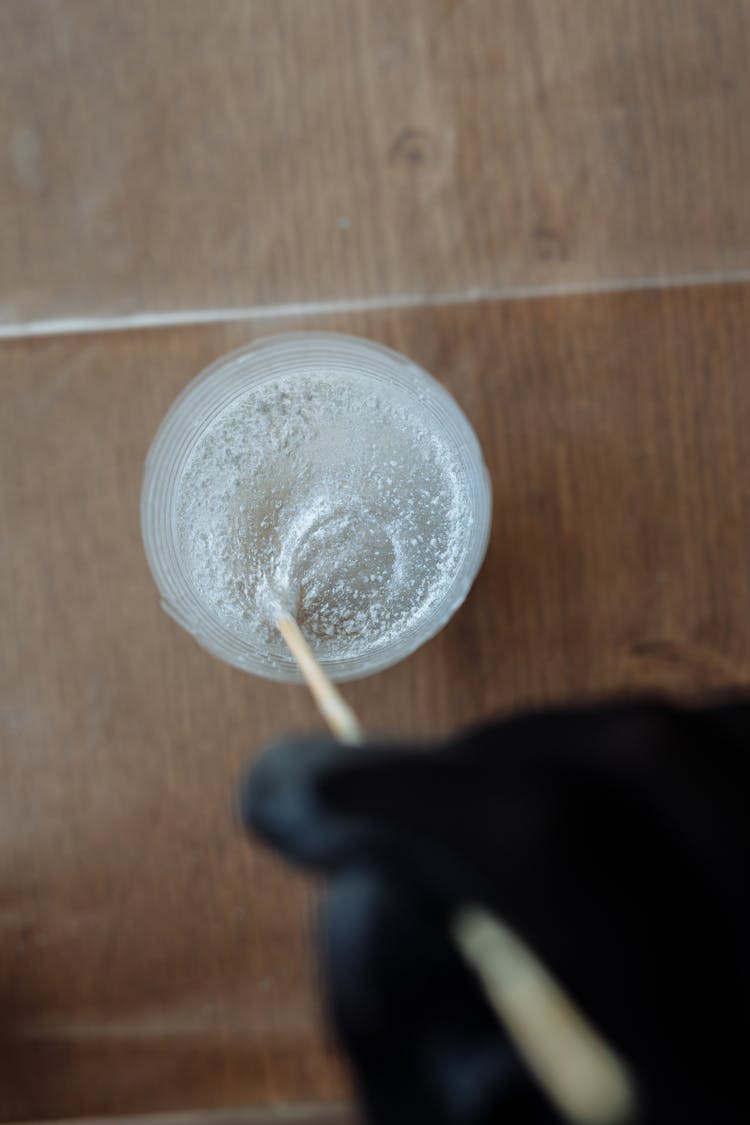 Person Mixing Sparkly Liquid In A Glass