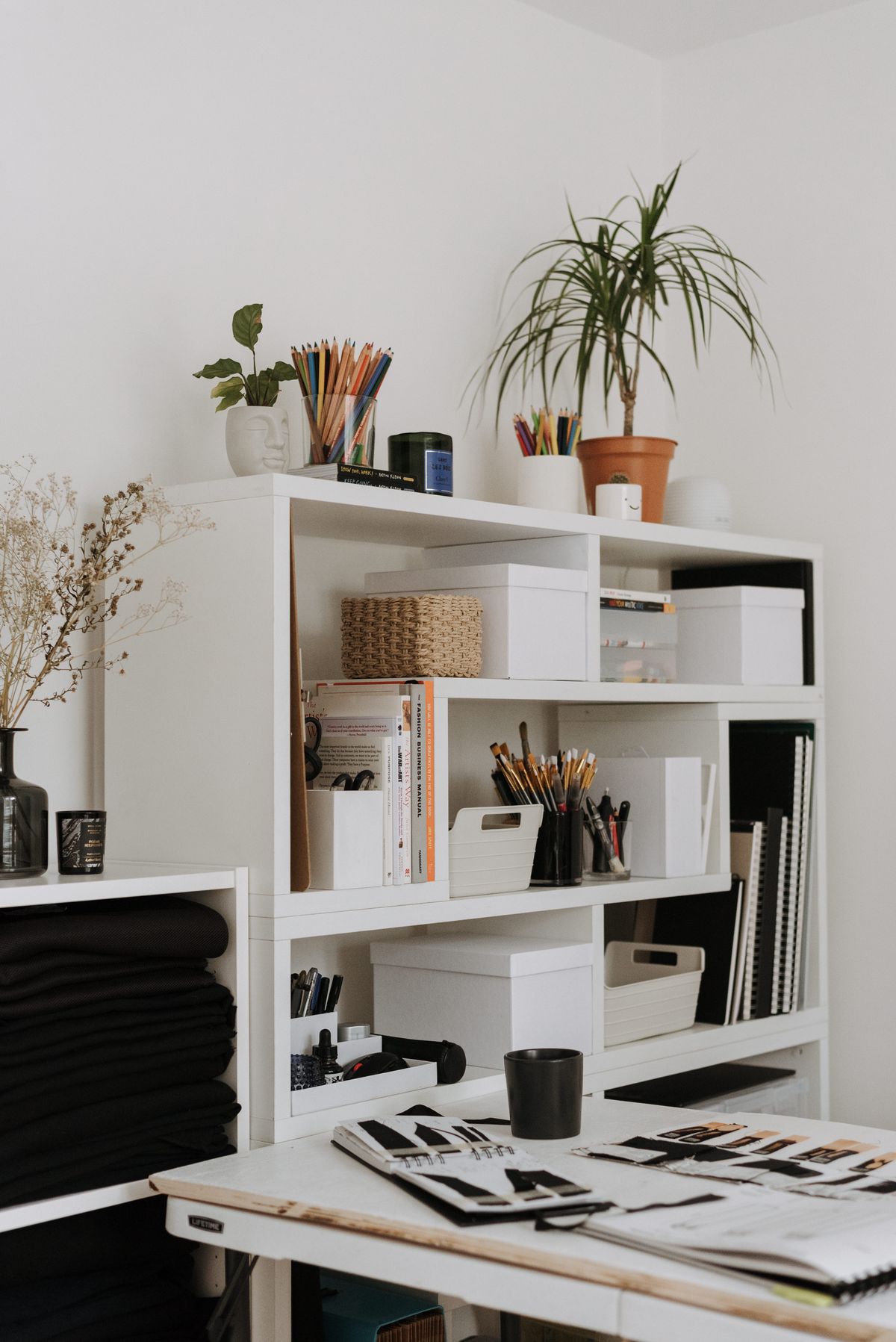 Sketchbooks and stationery supplies stored on studio shelves