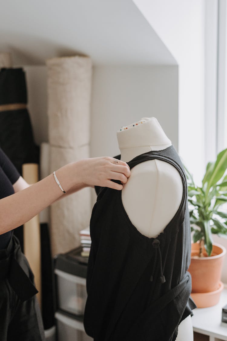 Crop Woman Adjusting Vest On Mannequin